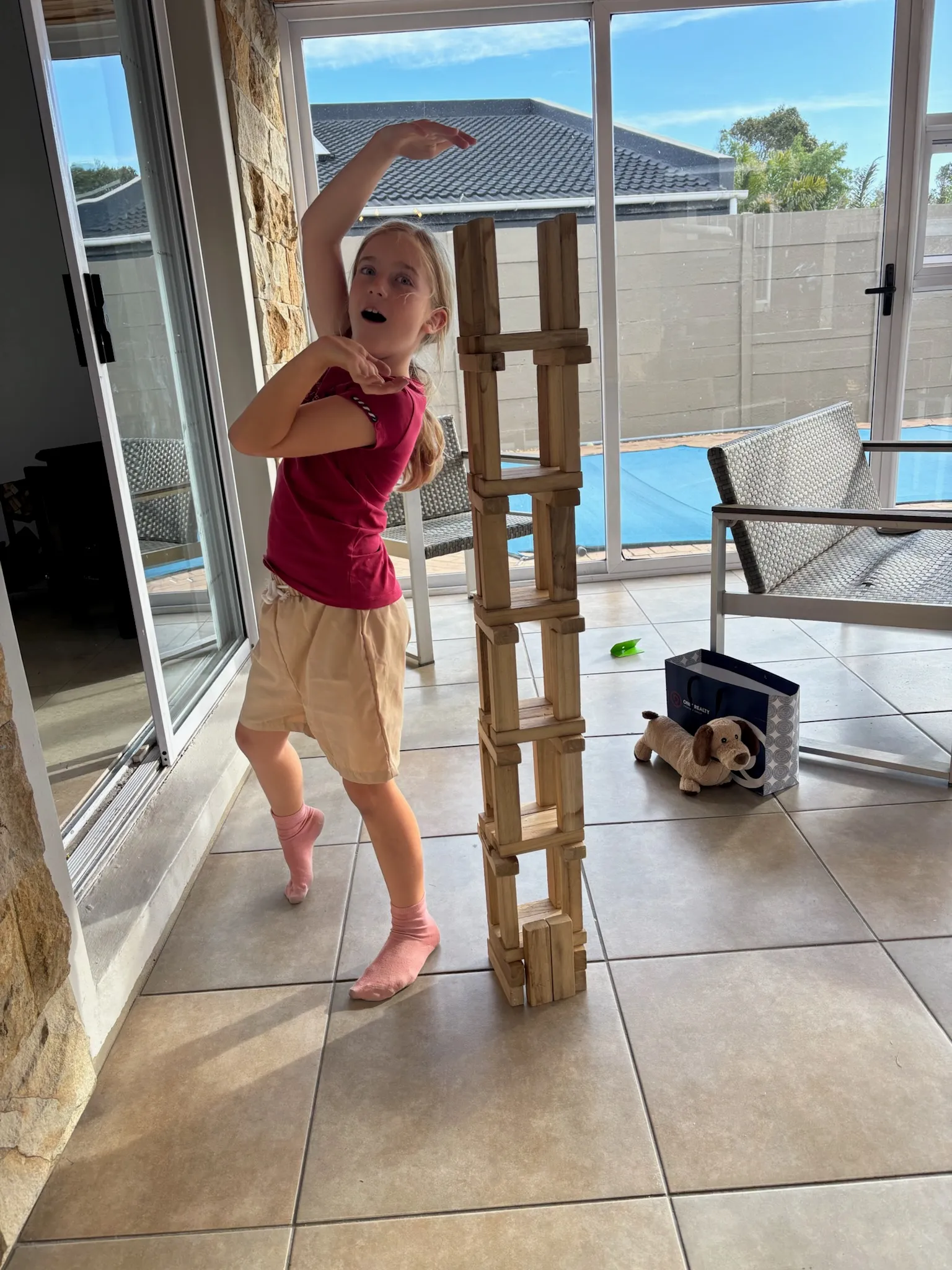 Merle baut einen hohen Turm aus Holzklötzen